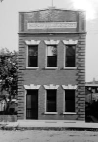 black and white photo with a building and a tree