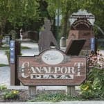 Canalport Plaza sign with flowers in park setting.