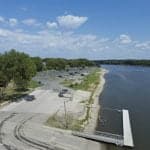 Riverfront park with boat launch and parking area.