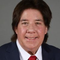 Man smiling in suit with red tie