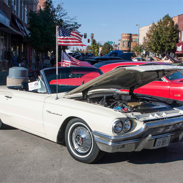 white car with hood up and red car in the background